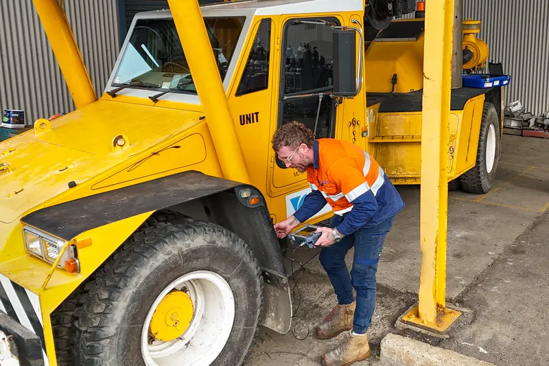 APEC technician eddy current testing the chassis of a mobile crane