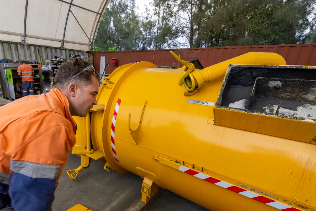 APEC Inspection inspector examining the exterior of a pressure vessel beside its open hatch