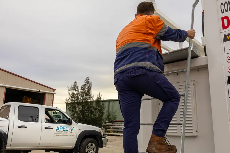 APEC technician climbing an access ladder on site