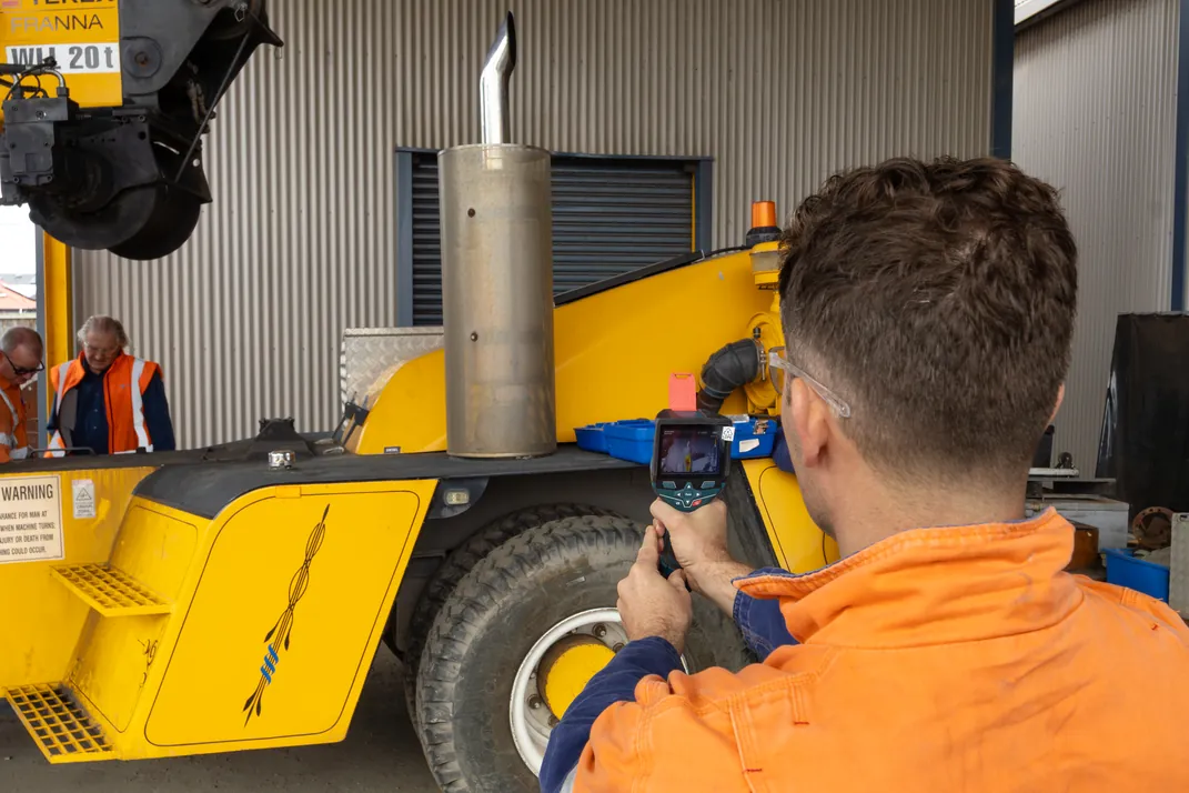 APEC technician carrying out a thermal imaging survey on a mobile crane in a workshop