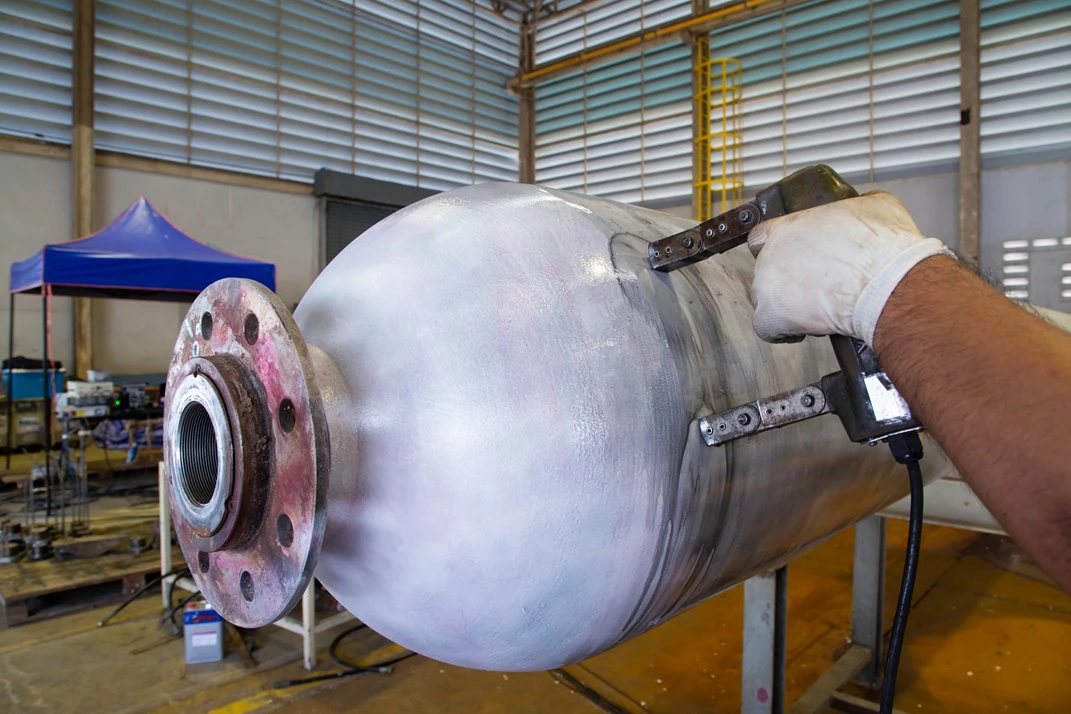Wet magnetic particle test on outside surface of the seamless pressure vessel.
