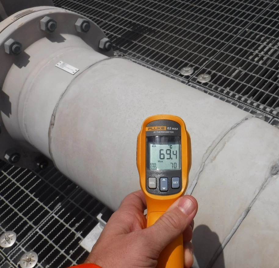 Spot temperature reading taken on insulated pipework with a handheld infrared thermometer